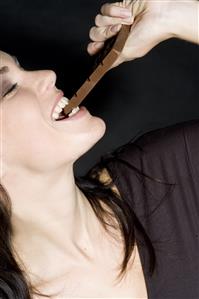 woman biting chocolate bar