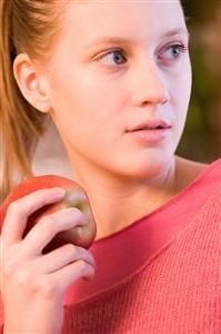 young woman holding red apple