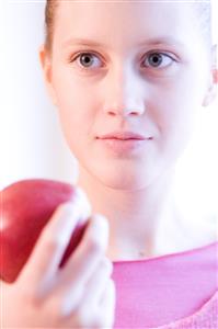 young woman holding red apple