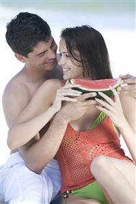 couple eating watermelon on beach