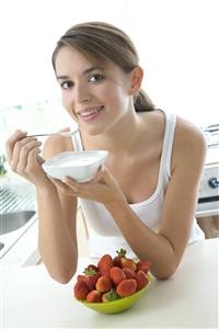 Mujer comiendo yogur y fresones.