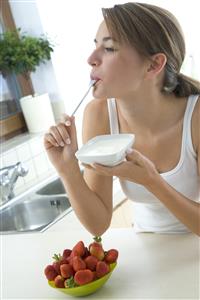 Mujer comiendo yogur y fresones.