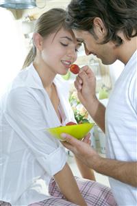 Pareja en la cocina. El, le da un freson.