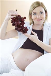 pregnant woman eating grapes