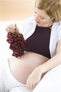 pregnant woman eating grapes