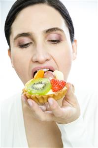 woman eating fruit cake