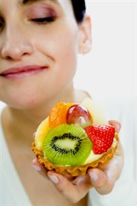 Mujer comiendo una tartaleta de frutas. Alta resolución disponible. Contactar con: firofoto@firofoto.com Telf.: 93 211 25 93