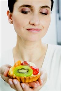 Mujer comiendo una tartaleta de frutas. Alta resolución disponible. Contactar con: firofoto@firofoto.com Telf.: 93 211 25 93