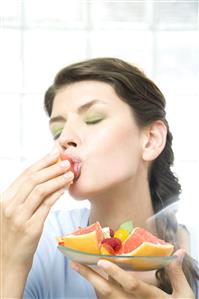 Mujer comiendo fruta. Primer plano.