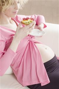 pregnant woman eating fruit cake