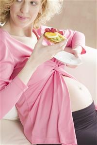 pregnant woman eating fruit cake