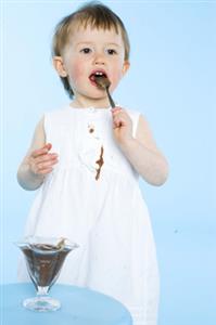 Niña comiendo un postre de chocolate y manchandose el vestido blanco. Todas las resoluciones disponibles. Contacta con: firofoto@firofoto.com Telf.: 93 211 25 93 