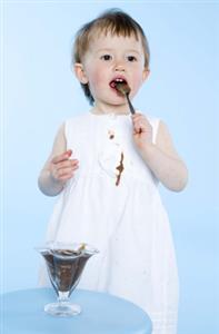 Niña comiendo un postre de chocolate y manchandose el vestido blanco. Todas las resoluciones disponibles. Contacta con: firofoto@firofoto.com Telf.: 93 211 25 93 