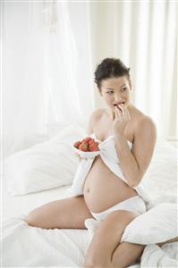 pregnant woman eating strawberries