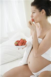 pregnant woman eating strawberries