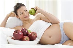 pregnant woman eating apples