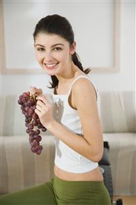 young woman eating grapes