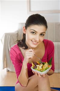 young woman eating fruit salad