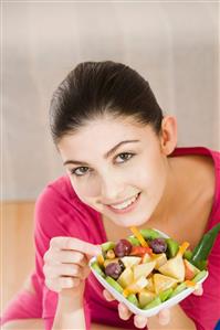 young woman eating fruit salad