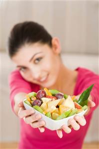 young woman eating fruit salad