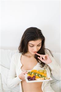 young woman eating fruit salad