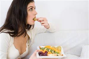 young woman eating fruit salad