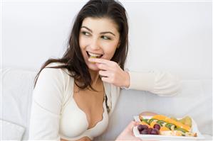 young woman eating fruit salad