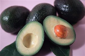 Varios aguacates, uno abierto por la mitad. 