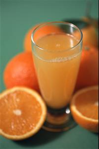 Naranjas y un vaso de zumo de naranja.