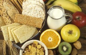 Desayuno a base de alimentos dieteticos: galletas de arroz, pan integral, fruta, leche y cereales.