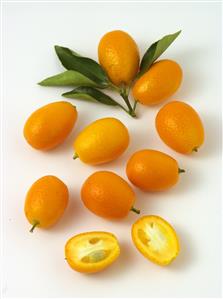 Kumquat. Varios frutos enteros y uno, partido.