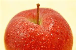 Manzana cubierta de gotas de agua. Detalle.