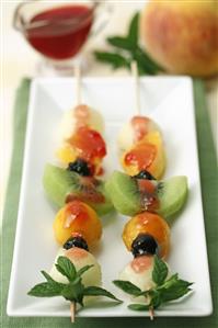 Brochetas de fruta con jalea de grosellas.