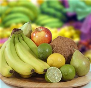 Plato de frutas: platanos, coco, manzana, peras, limas y limon.                              