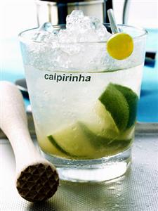 Caipirinha with ice cubes, wooden pestle