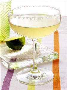 Lime cocktail in a champagne glass with sugared rim, lime