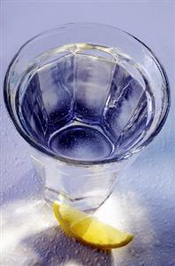 Glass of mineral water in blue, wedge of lemon