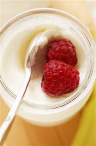 Jar of yoghurt with fresh raspberries
