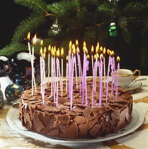 Chocolate cake with many burning candles