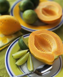 Halved papaya with lime wedges