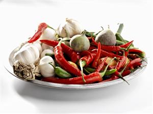 Chillies, figs, garlic cloves in a dish