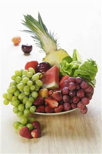 Plate of fruit: grapes, melon, pineapple, strawberries etc.