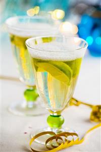 Two glasses of sparkling wine with lemon wedges