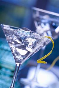 Martini with lemon peel and ice cubes