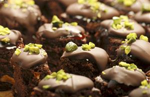 Brownies with redcurrant jelly, chocolate icing & pistachios