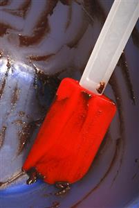 Bowl with remains of cake mixture and spatula