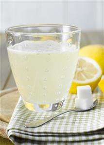 Hot lemon with sugar cubes, lemons in background