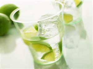 Mineral water with pieces of lime and ice cube