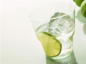 Mineral water with slice of lime and ice cube