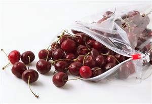 Cherries falling out of a plastic bag